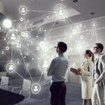 People analyze digital network connections in conference room.