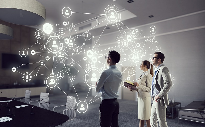 People analyze digital network connections in conference room.