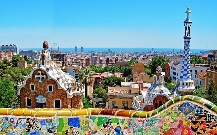 Park Güell view with Gaudí architecture, Barcelona skyline.