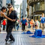 Street dancers performing in a busy urban setting.