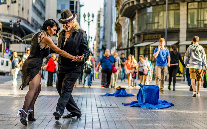 Street dancers performing in a busy urban setting.
