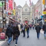 People walking on Dublin city street with shops