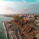 Aerial view of coastal city with cliffs and ocean.