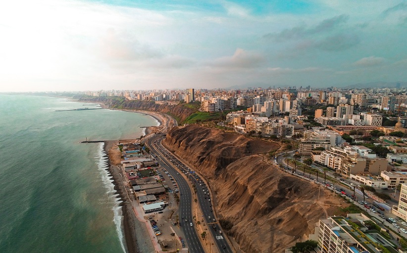 Aerial view of coastal city with cliffs and ocean.