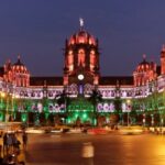 Mumbai's CST illuminated at night with colorful lights.