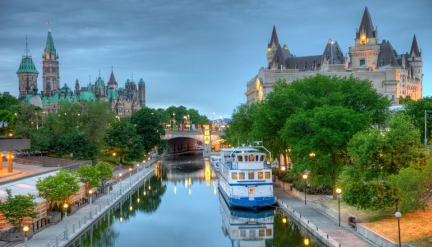 Ottawa Rideau Canal with boat and historic buildings.