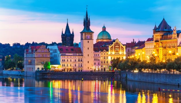 Colorful Prague cityscape at sunset with river view.