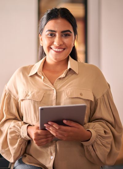 Smiling woman holding a tablet indoors