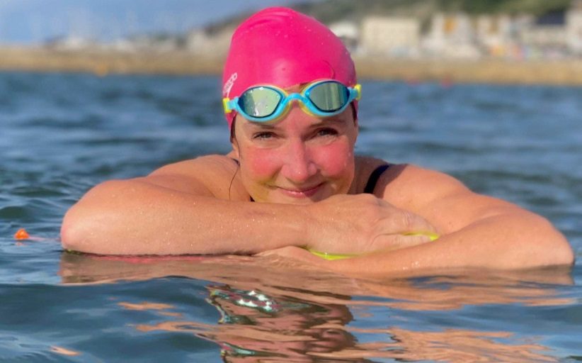 Claire Stephens, a vice president at BCD Travel, takes in the water during training for an open water swim.