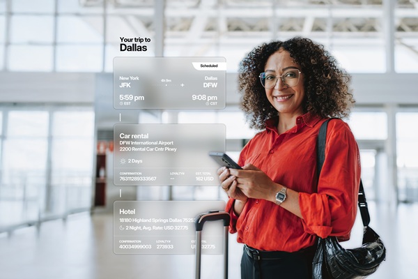 Traveler checks phone beside Dallas trip itinerary
