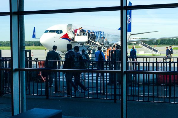 Passengers board commercial airplane at airport gate