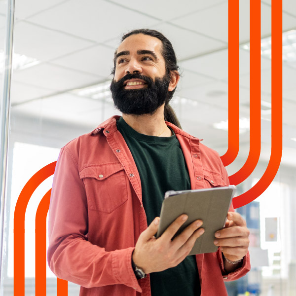 Smiling man holding tablet in modern office