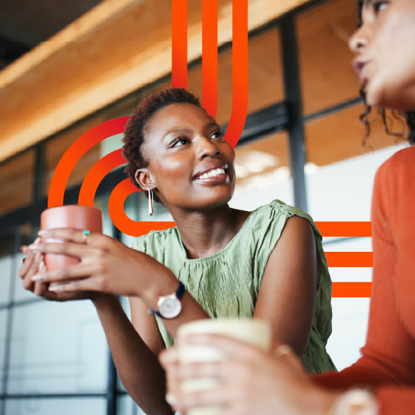 Two women chatting over coffee indoors