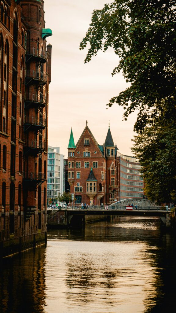 Historic brick building by canal at sunset.