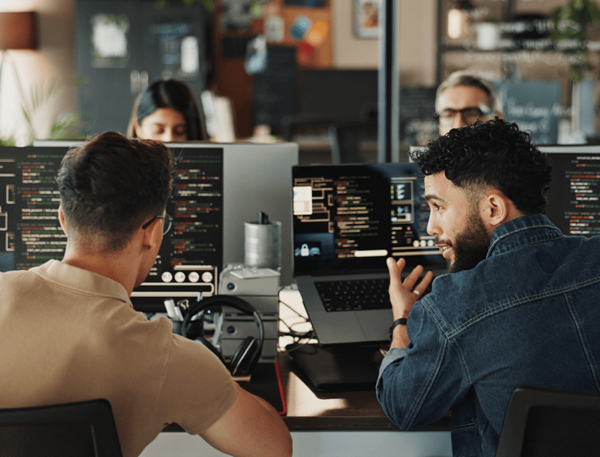 Two developers collaborating at computers in modern office