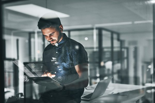 Man using transparent digital tablet in modern office