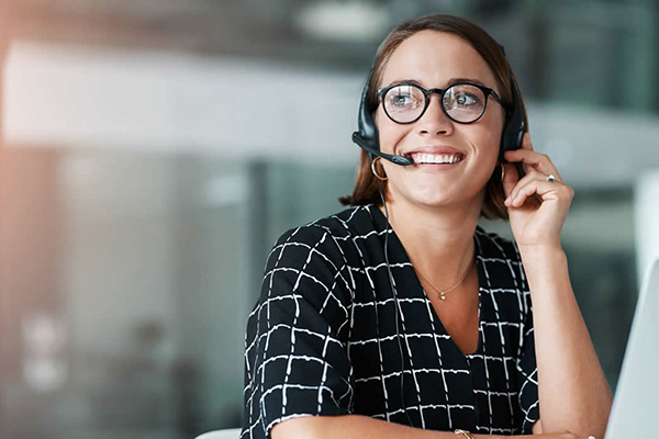Smiling customer service representative wearing headset and glasses
