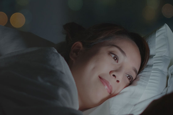 Woman lying awake in bed at night