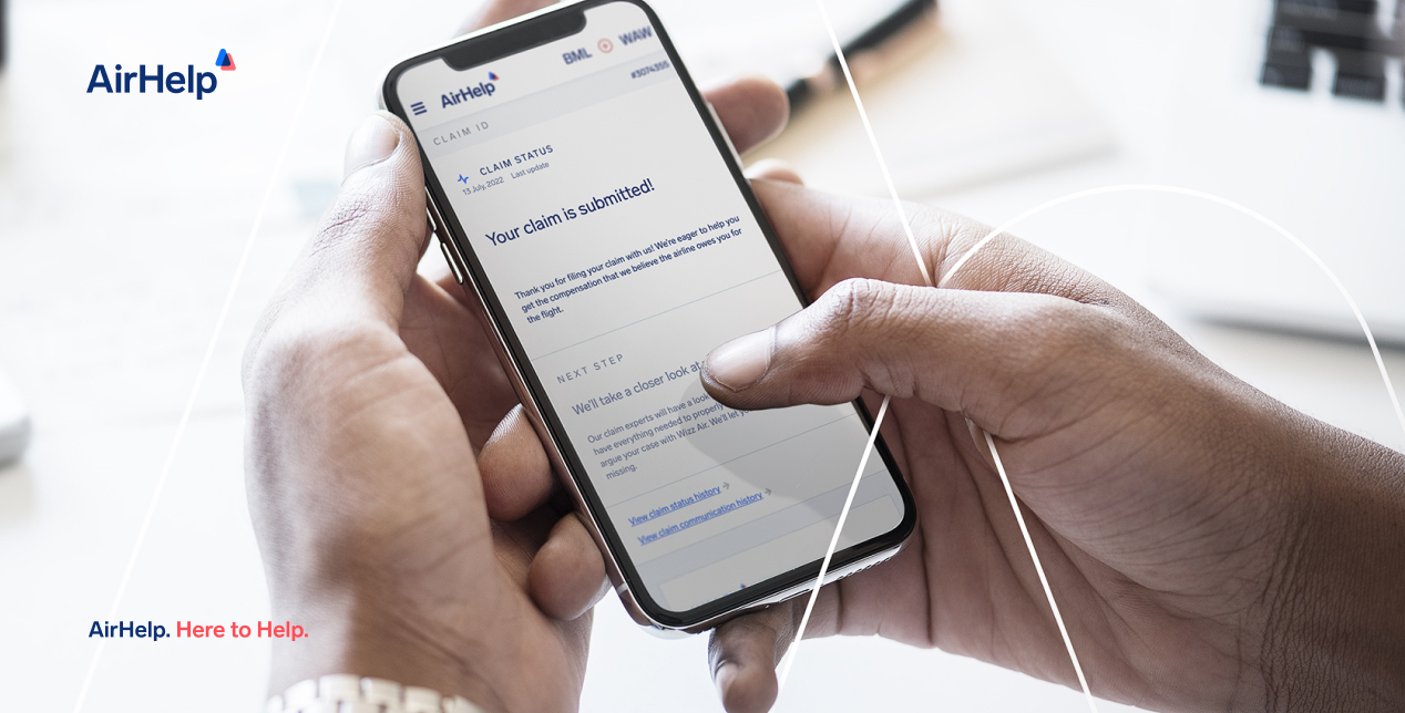 Person holding smartphone with AirHelp claim confirmation screen