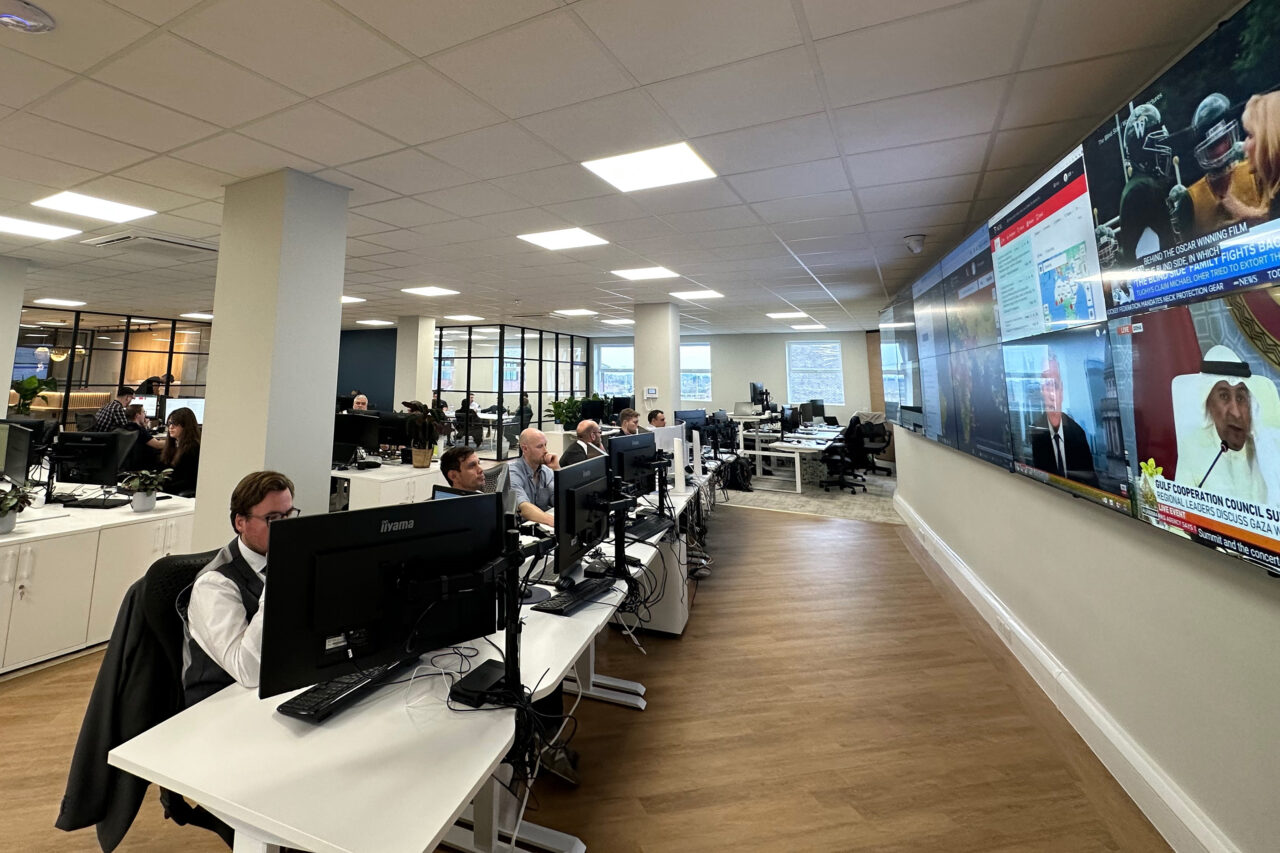 Modern newsroom with staff watching large video wall