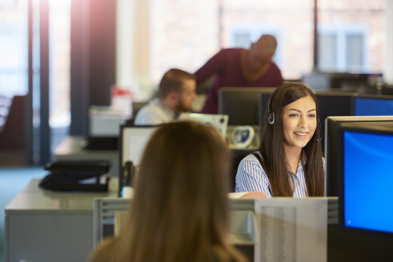 Customer service representative wearing headset in office
